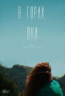 В горах. Она